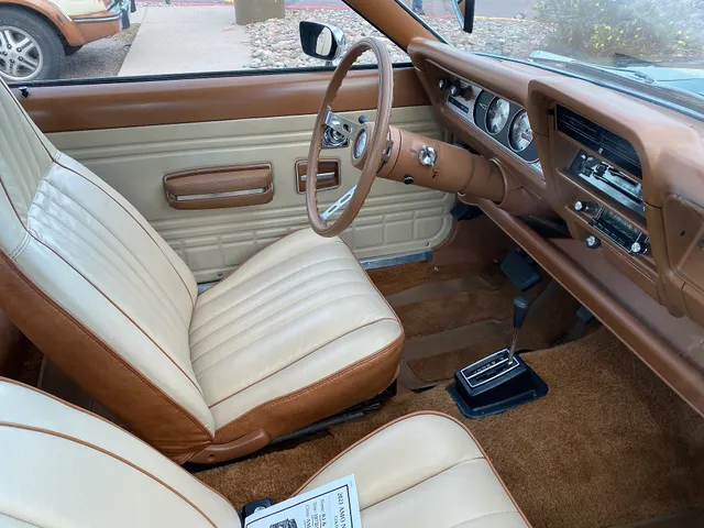 Exact-year Gremlin X cabin retained for bucket seats, vinyl trim, sports steering wheel, instrument panel, floor-shift Torque-Command selector, air conditioning, radio, pedals, carpeting, and door trim; it is not a Levi's-trim example.