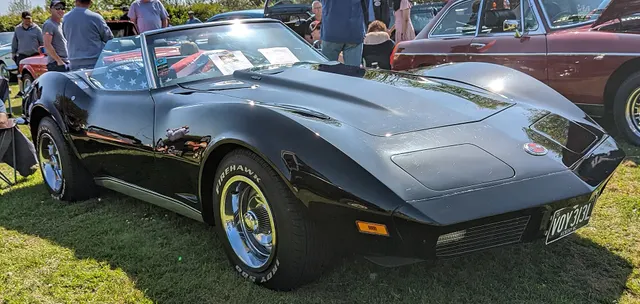 Black 1973 roadster viewed from the left front, showing the open two-seat cabin and convertible body; visible equipment is not proof of drivetrain or option identity.