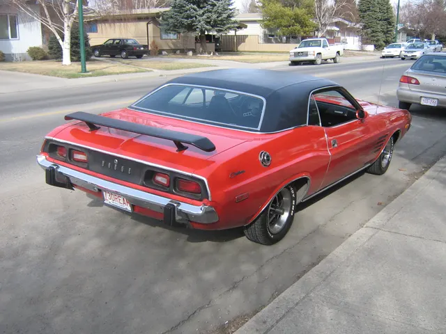 Rear view of the restored red 1973 Challenger; spoiler and trim are visible context only
