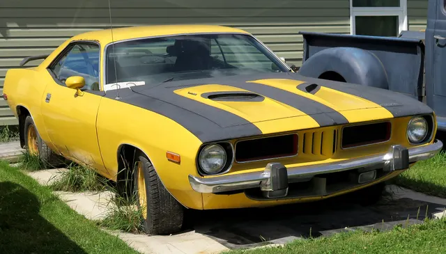 Companion view of a weathered 1973 Plymouth Barracuda 340 showing body, glass, hood, and bumper details