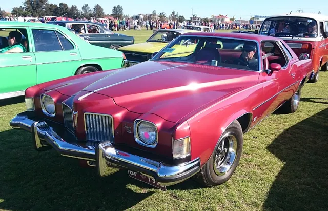 Exact-year front three-quarter view retained for the V-shaped grille, headlamps, bumper, hood, fenders, windshield, roof, body moldings, and Rally-style wheel context; finish, tires, and equipment remain subject-specific.