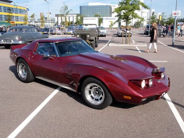 Red 1974 coupe with its concealed headlamps raised, showing the four-lamp mechanism, front openings, urethane nose, and Rally wheels.