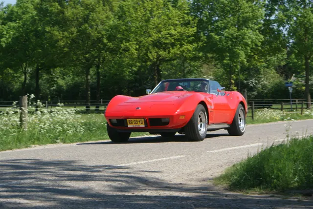 Red 1975 convertible in motion, retained as final-year-convertible history context; its wheels and current equipment are not factory-option proof.