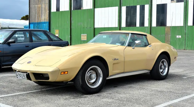Medium Saddle coupe in front three-quarter view, showing the urethane nose, concealed headlamps, long hood, fender vent, and steel wheels; current condition is visible context, not an originality claim.