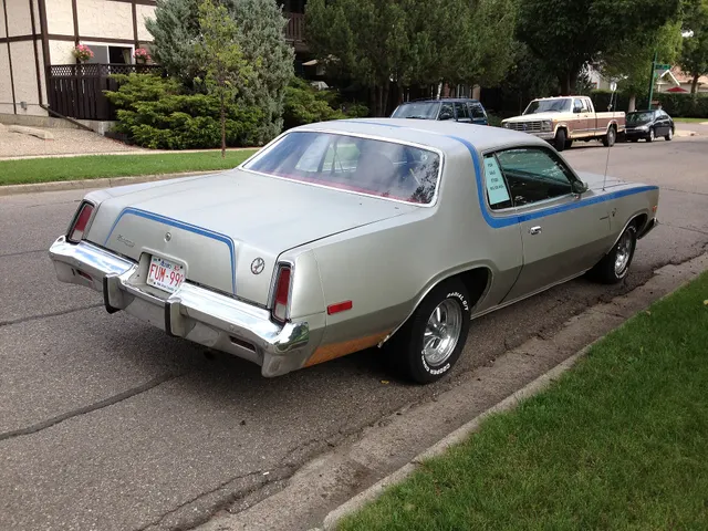 Rear three-quarter view of the same exact-year car retained for the deck, vertical lamps, bumper, quarter shape, stripe, glass, and stance.