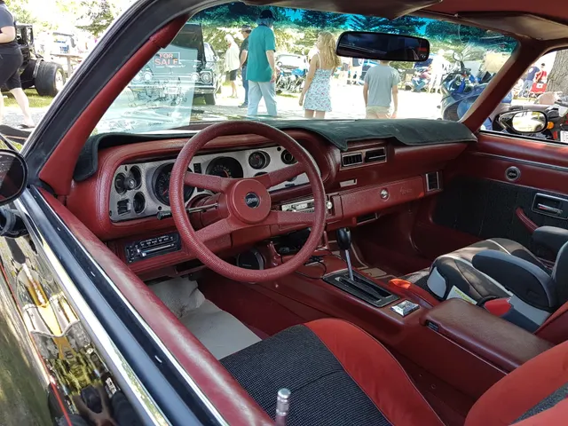 Exact-year Z28 cabin retained for dashboard, instruments, steering wheel, console, automatic shifter, door trim, and seating context; the dash cover, child seat, and other accessories are not presented as factory equipment.