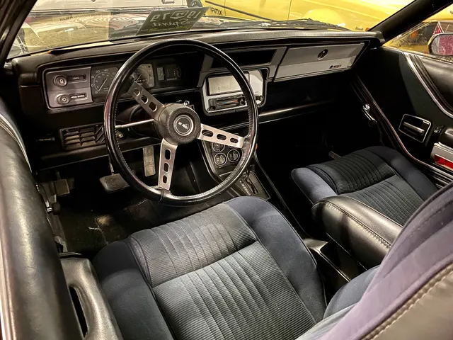 A photographed 1979 Spirit AMX cabin showing bucket-seat upholstery, door trim, three-spoke steering wheel, instrument panel, center gauges, console, and automatic selector; trim, transmission, restoration, and condition remain specific to this car.