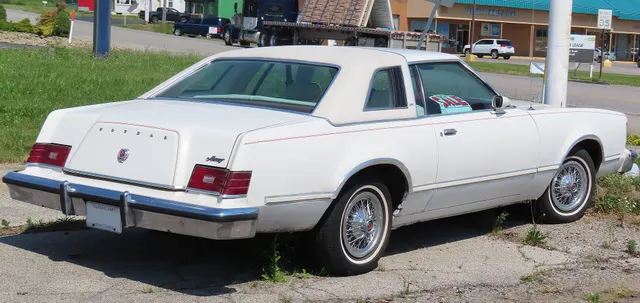 Rear view of the same white XR-7 retained for the padded Landau roof, opera-window louvers, deck treatment, horizontal-theme lamps, bumper, scripts, moldings, and stance.