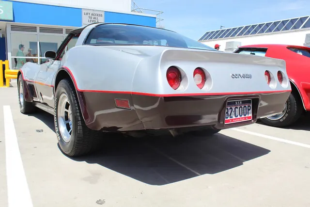 Exact-year regular Sport Coupe rear three-quarter view retained for the fixed fastback glass, roof panels, integral rear spoiler, lamp recesses, two-tone finish, pinstriping, and factory-style wheel context; appearance does not establish Collector Edition identity.