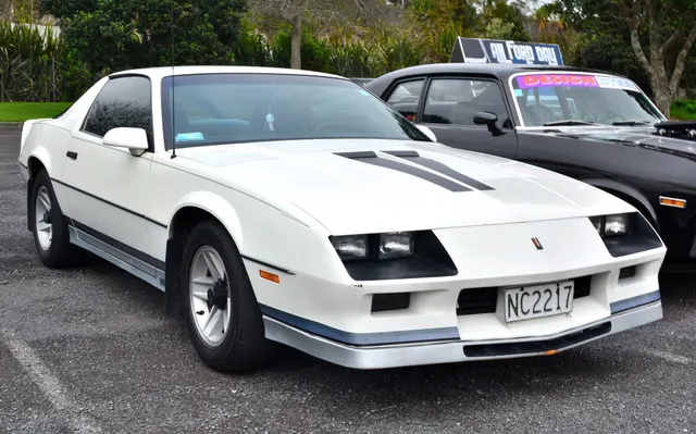 A photographed 1984 Camaro Z28 showing white paint, hood graphics, lower-body stripe treatment, Z28 badging, lamps, glass, and factory-style wheel context; finish, equipment, condition, and individual-car originality remain specific to this car.