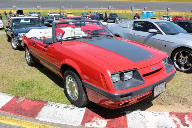 Exact-year Bright Red GT convertible retained for the power-top body, windshield, doors, quarter glass, revised nose, hood graphic, air dam, fog lamps, side moldings, 5.0 identification, and factory-style wheel context.