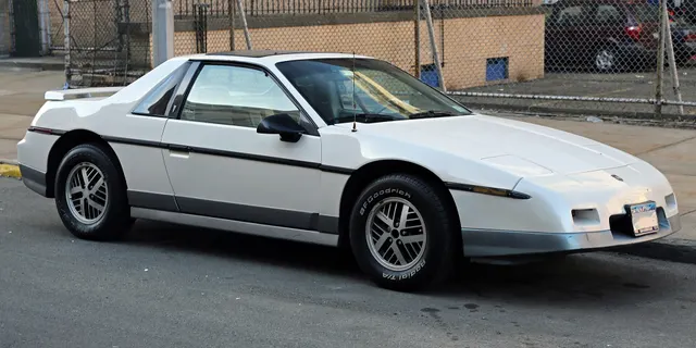Opposite front-quarter view of the same exact-year GT retained for the aero nose, closed retractable lamps, hood, windshield, sunroof, mirrors, skirts, wheel treatment, and lower accent.
