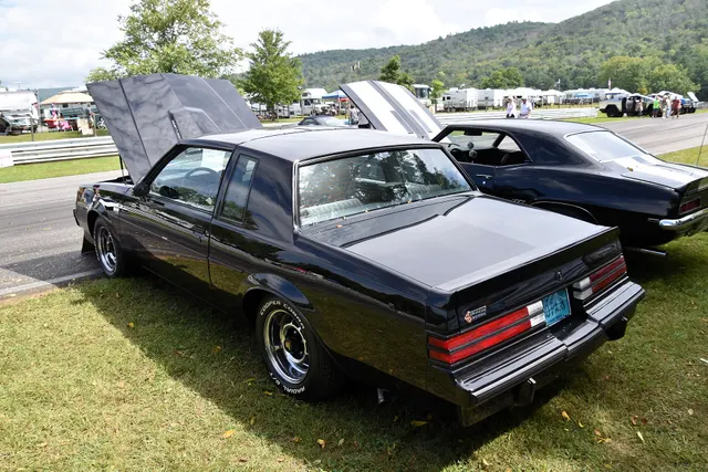 Frozen-review exact-year rear-quarter view retained for the roof, rear glass, quarter, three-piece spoiler, lamps, bumper, Grand National emblem, chrome sport wheels, and open-hood context.