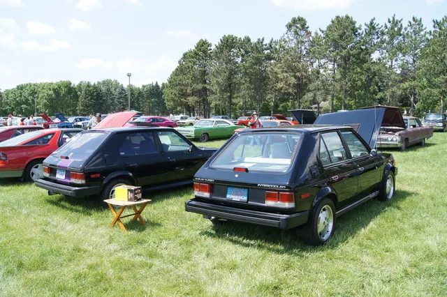 Exact-year rear-quarter view retained for the stock-presenting GLH-S at right, including hatch, rear glass, lamps, bumper, Shelby Turbo and Intercooled marks, Centurion wheel, and body proportions; the modified second car is background context only.