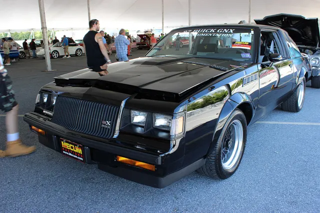 Exact-subject front three-quarter view retained for the GNX grille badge, lamps, air dam, hood, fender vents, flares, black mesh wheels, tire fit, mirrors, and stance; auction markings and current condition belong only to the photographed car.