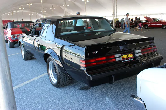 Exact-subject rear three-quarter view retained for the deck-lid GNX badge, spoiler, lamps, bumper, widened wheel openings, rear wheel and tire, roof, glass, and body proportions; auction context and current condition remain subject-specific.