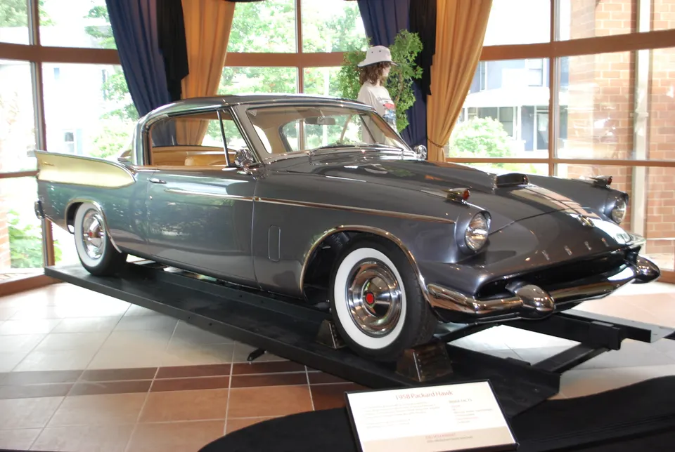 Modified deck lid with raised spare-tire form, Packard script, crest, and lock profile photo