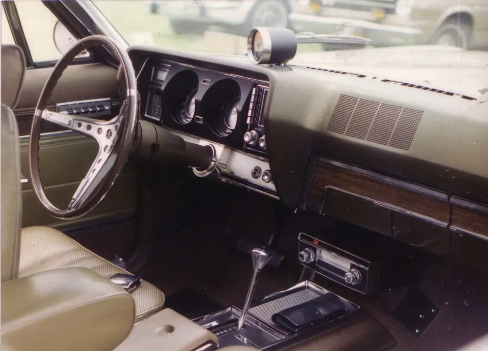 Woodgrain instrument and door trim, with engine-turned trim documented on early production profile photo